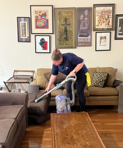 woman using vacuum to clean sofa couch, house cleaning service in charlotte nc
